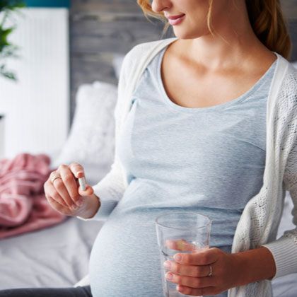 Pregnant woman taking pill